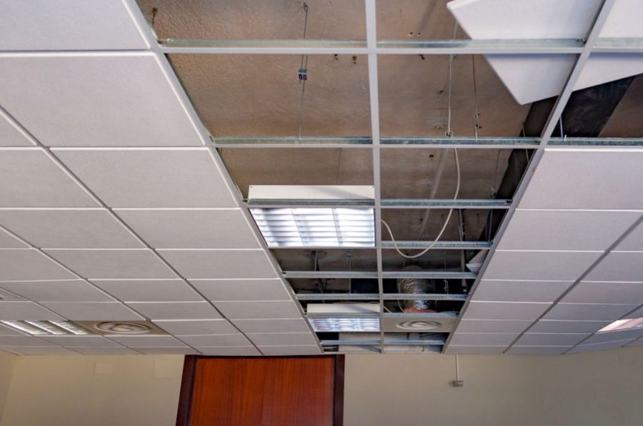 Abgehängte Rasterdecke während der Montage, teils offene Deckenfelder mit sichtbarer Unterkonstruktion und Beleuchtung.